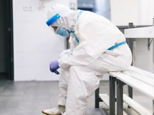 image-thoughtful-man-wearing-protective-suit-sitting-on-bench-in-hospital